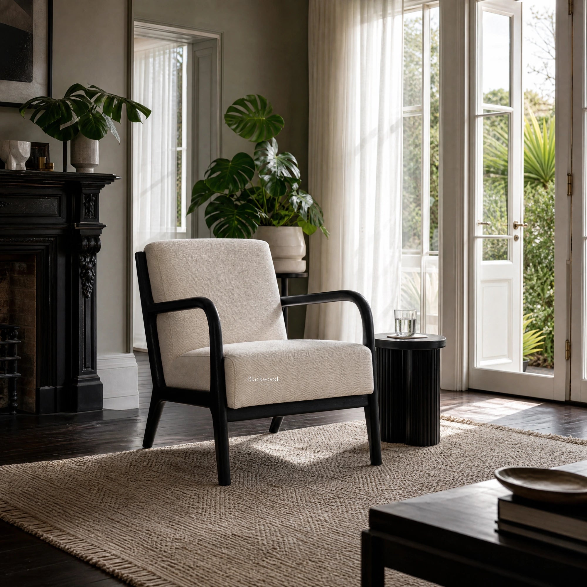 Java Occasional Chair - Black/Oat, cream upholstery with black frame in a sunlit living room by glass doors.
