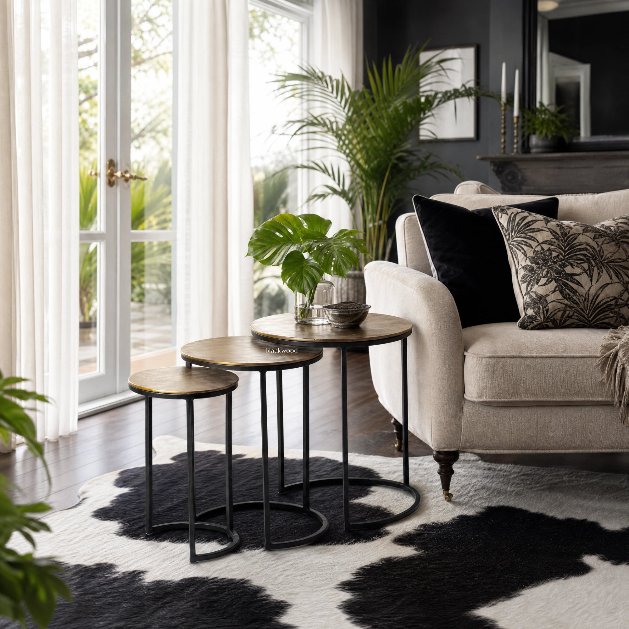 Calcutta Nesting Side Tables Set/3 with slender iron frames and softly aged aluminium tops in a stylish living room.