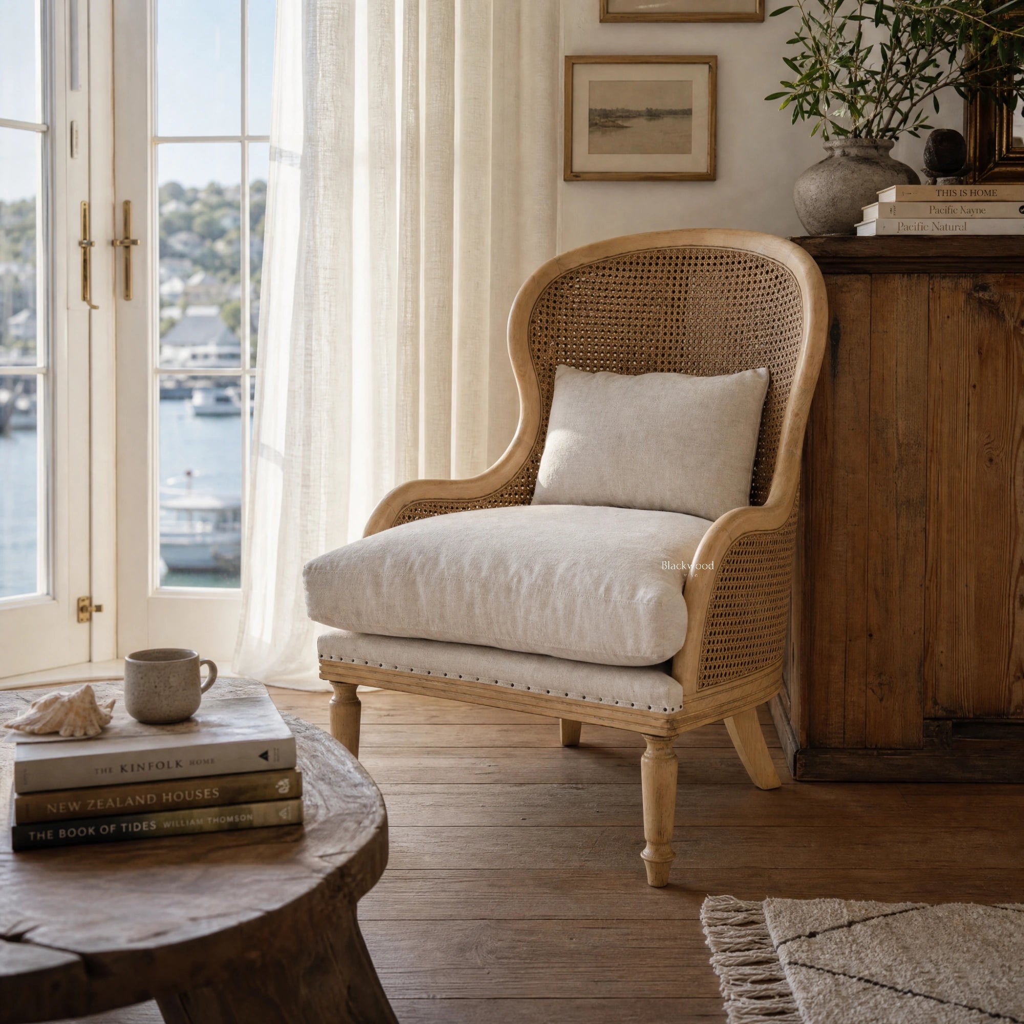 Bayview Lounge Chair with solid ash frame, woven natural rattan, and linen upholstery in a coastal living space.