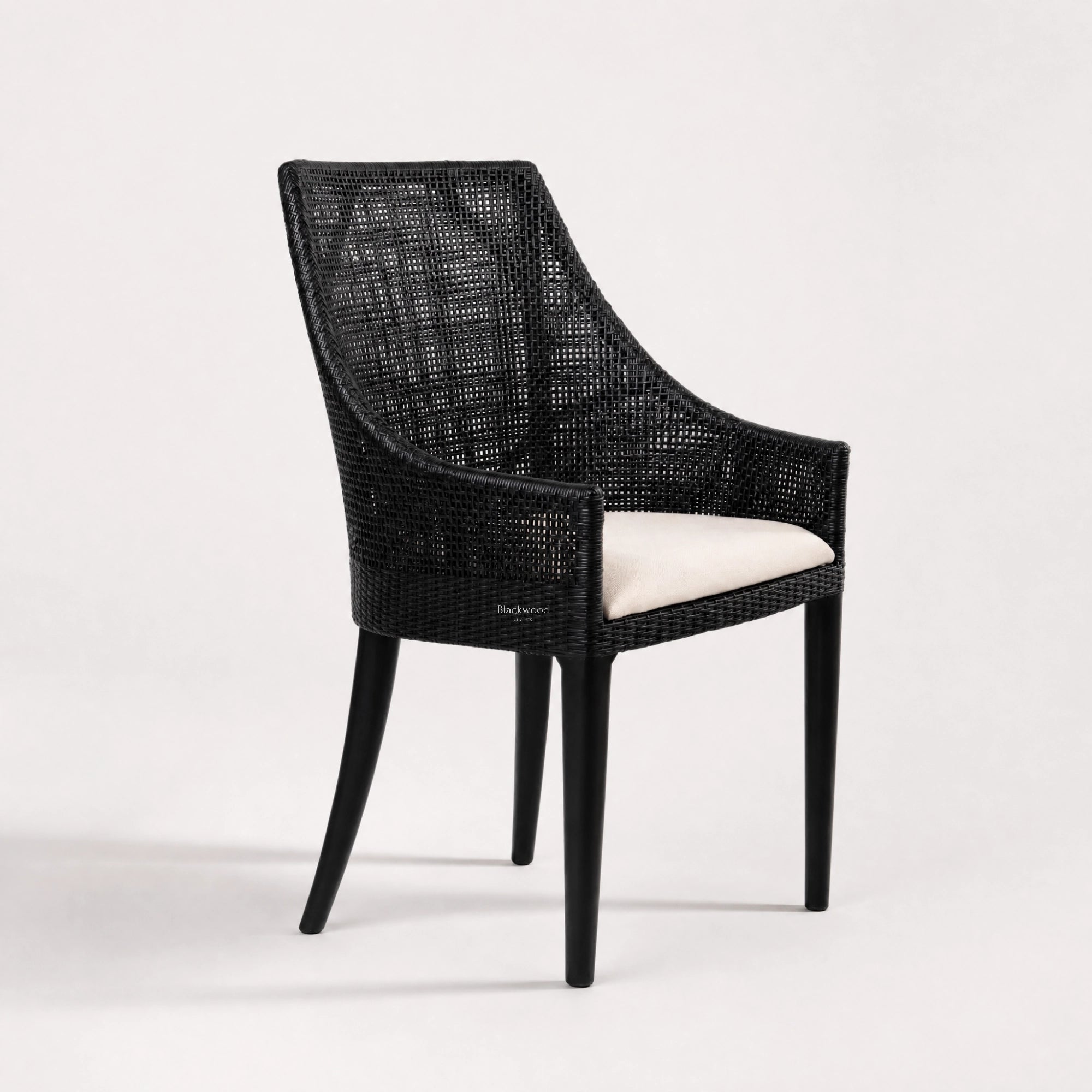 Barbados Dining Chair: black woven rattan with curved back and beige cushioned seat.