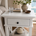 Bridgeport 1 Drawer Bedside - White with black knob, styled with vase, books, and glass on a white table.