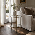 Belgrave Side Table - Brass with two clear glass surfaces and slender iron frame in a neutral living room.