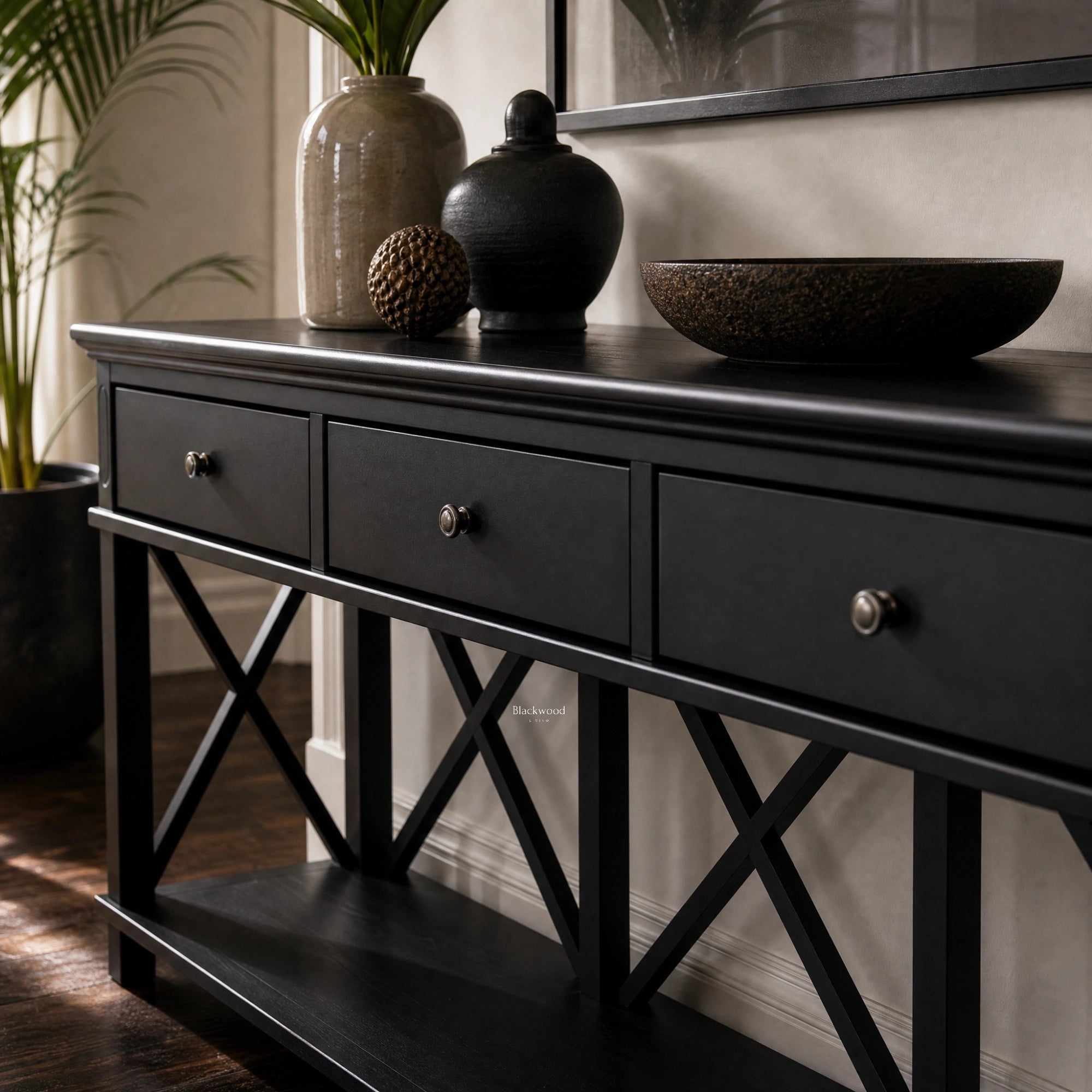 Bridgeport 3-Drawer Console in black with cross-braced legs and decorative vessels on top.