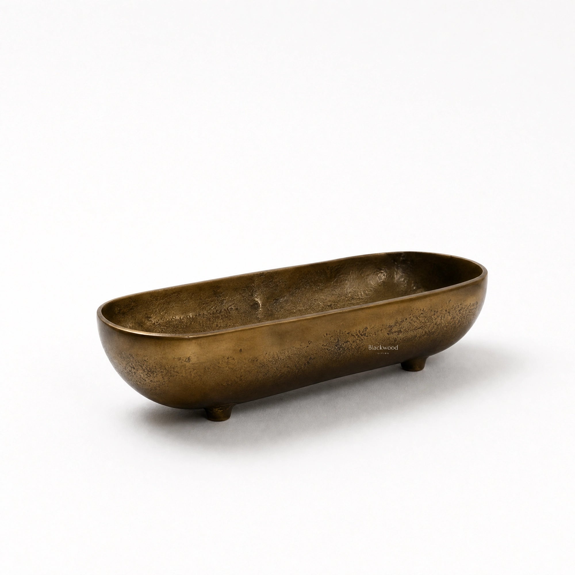 Madras Footed Bowl in antique brass finish, long oval aluminium bowl with textured surface and small feet.