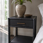 Rangoon Bedside Table - Black with a speckled vase holding a green plant and a decorative bowl.