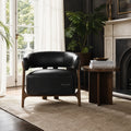 Black Alderton leather chair with curved back and solid ash timber frame in a sunlit living room.