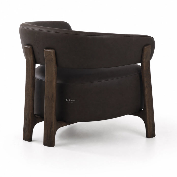 Rear view of black leather Alderton armchair featuring a curved back and solid ash timber frame with sturdy legs.