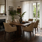Woven rattan Malabar dining chairs with solid timber frames arranged around a wooden table in a sunlit plantation-style room.