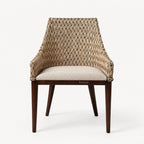 Plantation-style dining chair with hand-woven rattan back, solid timber frame, and cushioned seat.