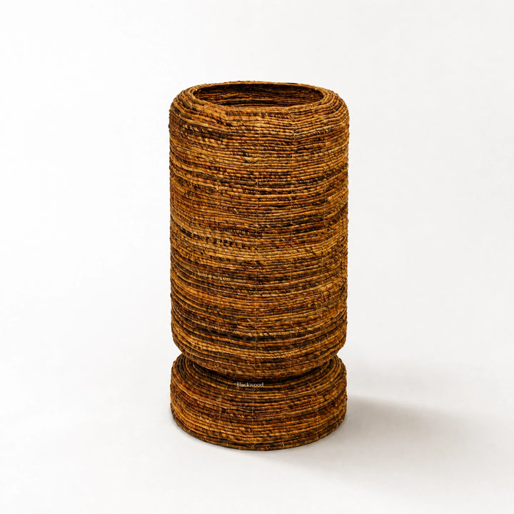 Large woven Ceylon planter with rounded form and textured banana leaf construction, featuring a pedestal base for tropical home decor.