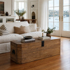 Reclaimed elm trunk with simple metal hardware serving as a nautical coffee table in a sunlit living room with waterfront views.
