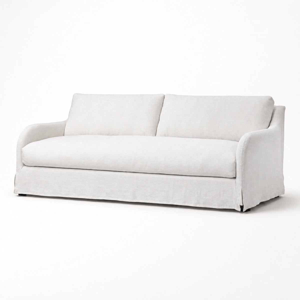 Monique Linen Slipcover Sofa with softly curved arms, loose silhouette, and full-length linen skirt.