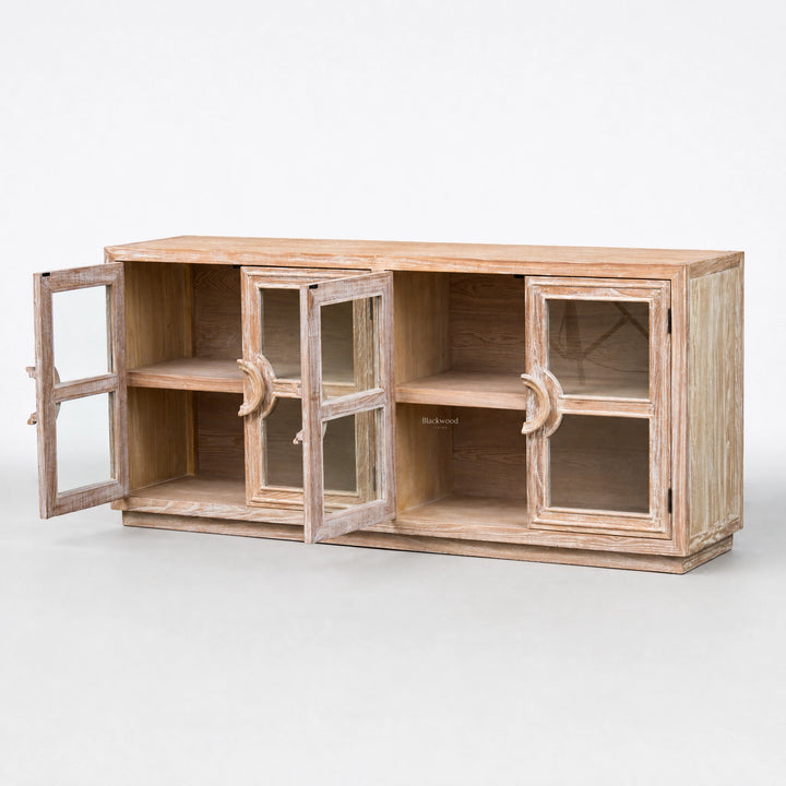 Wide elm sideboard with glass doors open to show interior shelves and a weathered coastal finish.