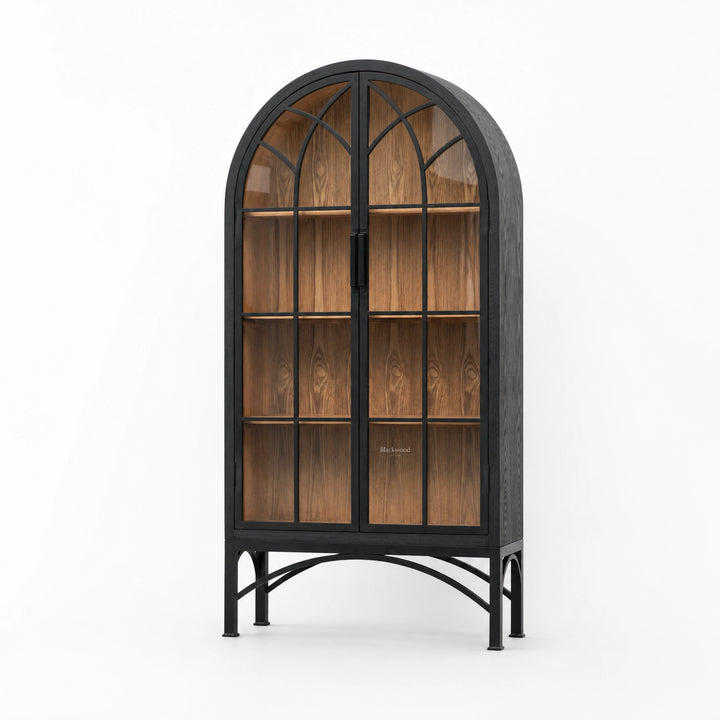Tall arched cabinet with glazed doors, dark metal frame, and warm wood interior on a scenic metal base.