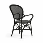 Black Rossini rattan armchair featuring a graceful curved frame, woven back, and finely bound joints.