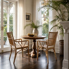 Antique handmade Indonesian rattan armchairs with braided seats and structured backrests flanking a wooden dining table.