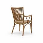 Antique rattan armchair with vertical backrest bars, braided seat, and wicker bindings on curved legs and arms.