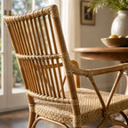 Handmade antique rattan armchair featuring a structured bar backrest, finely braided seat, and traditional wicker bindings in a sunlit room.