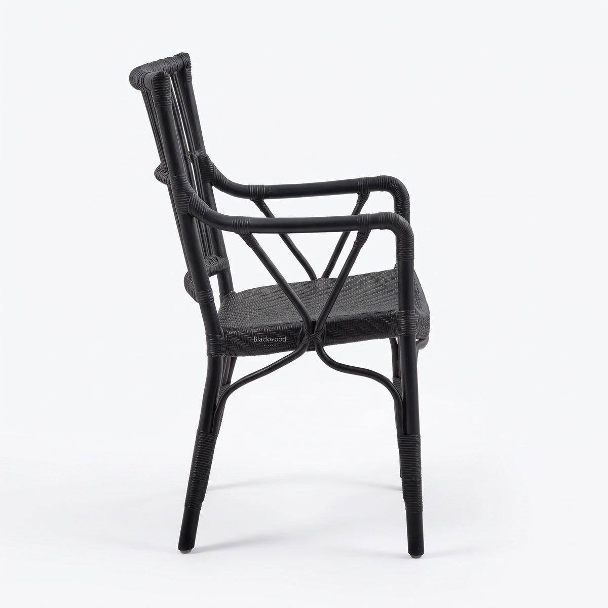 Black handmade rattan armchair with braided seat, structured backrest, and traditional wicker binding.