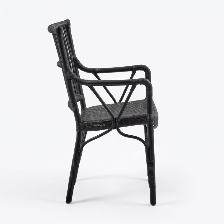 Black handmade rattan armchair with braided seat, structured backrest, and traditional wicker binding.