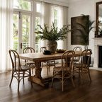 Sika Originals Lulu Rattan Side Chair arranged around a rustic wooden dining table in a sunlit room with French doors.