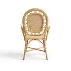 Handcrafted rattan armchair featuring a rounded back, intricate woven panels, and sustainable Indonesian rattan construction.