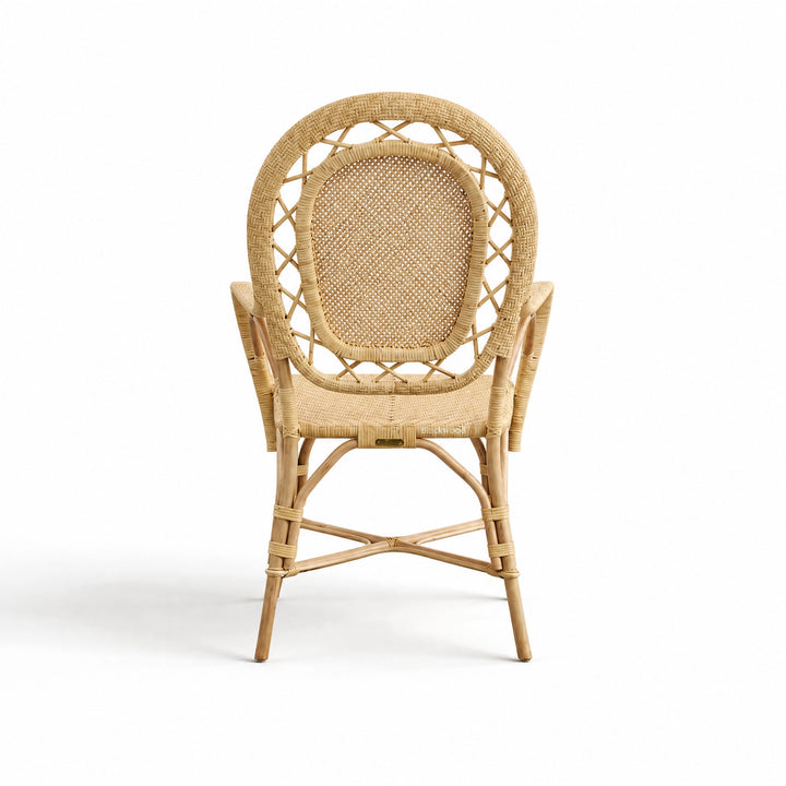 Handcrafted rattan armchair featuring a rounded back, intricate woven panels, and sustainable Indonesian rattan construction.