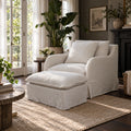 Henley Ottoman with cushioned top and skirted base in linen cotton blend, placed beside matching armchair on jute rug.