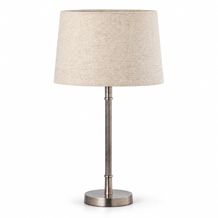 Clarendon table lamp with aged silver fluted metal base and tapered natural linen shade.