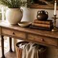 Bordeaux Hall Table in oak with visible grain, paired with ceramic vases, books and a candle.