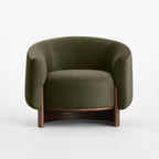 Fairfield Occasional Chair in moss mohair velvet with a curved silhouette and exposed timber legs.