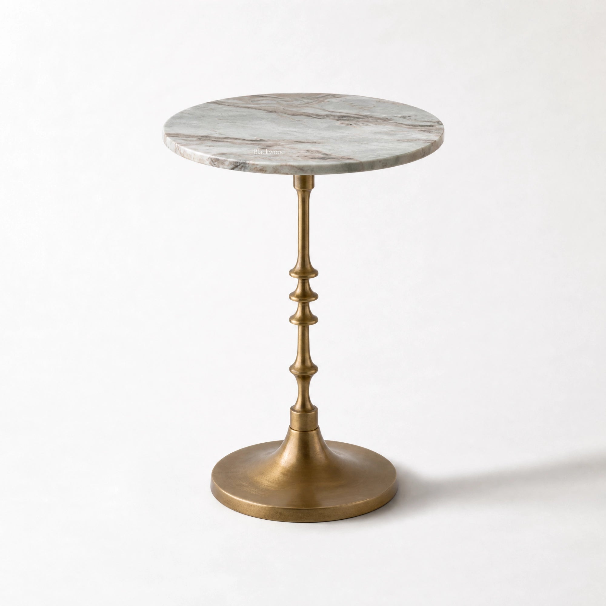 Marcel Side Table with a veined marble top and antique gold pedestal.