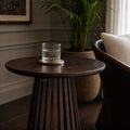 Banyan Side Table in cacao-stained solid oak with a slatted pedestal, styled in a living room.