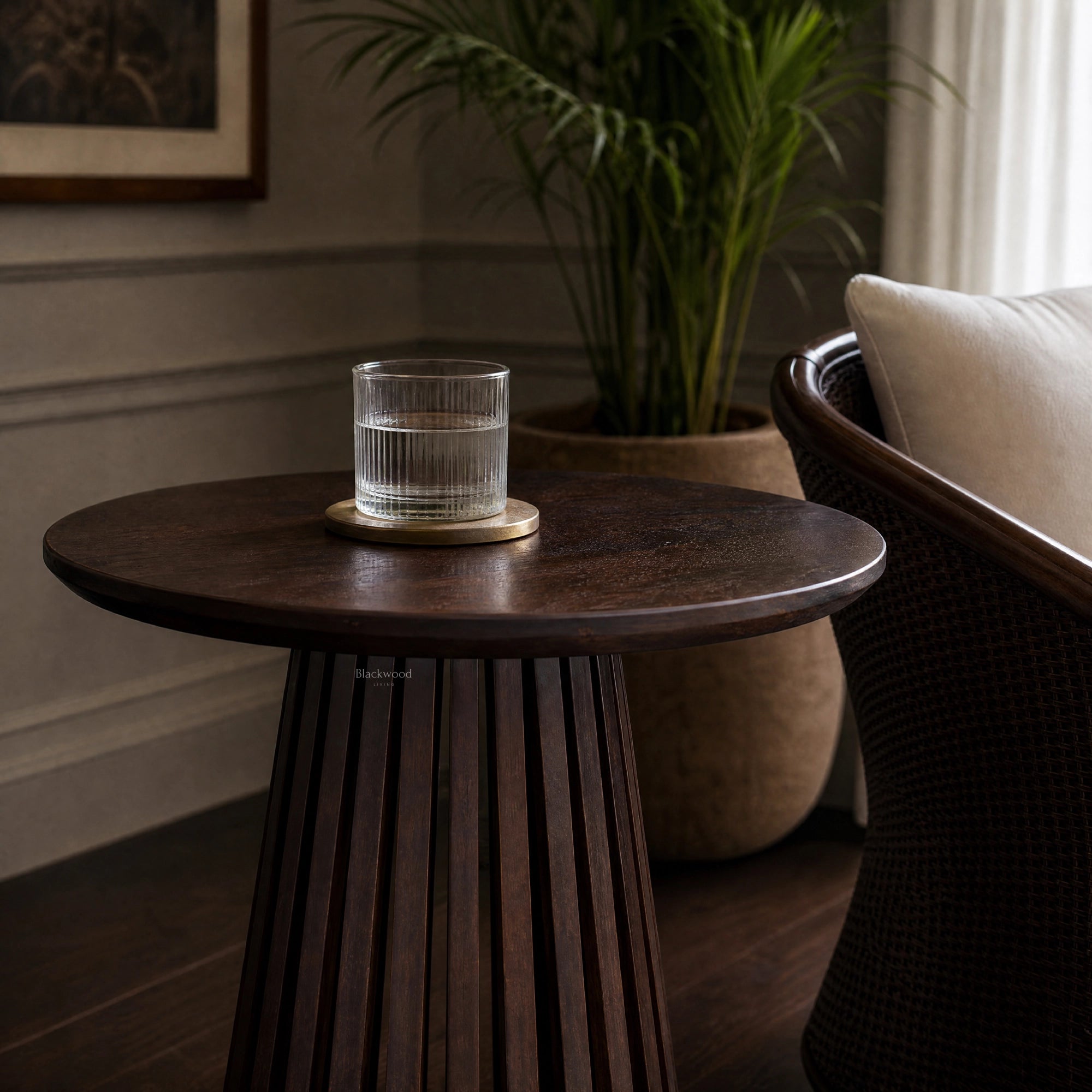 Banyan Side Table in cacao-stained solid oak with a slatted pedestal, styled in a living room.