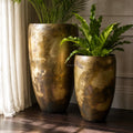 Nagar Planters Set/2 in handcrafted iron with antique gold finish and aged patina, two textured pots housing green plants.