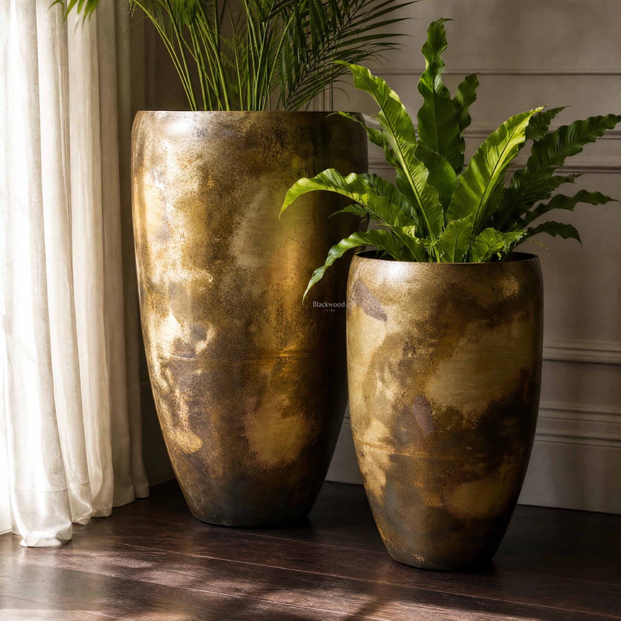 Nagar Planters Set/2 in handcrafted iron with antique gold finish and aged patina, two textured pots housing green plants.