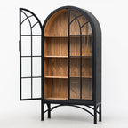 Tall arched display cabinet with black metal frame, glazed doors, and warm wood interior shelves on a metal base.