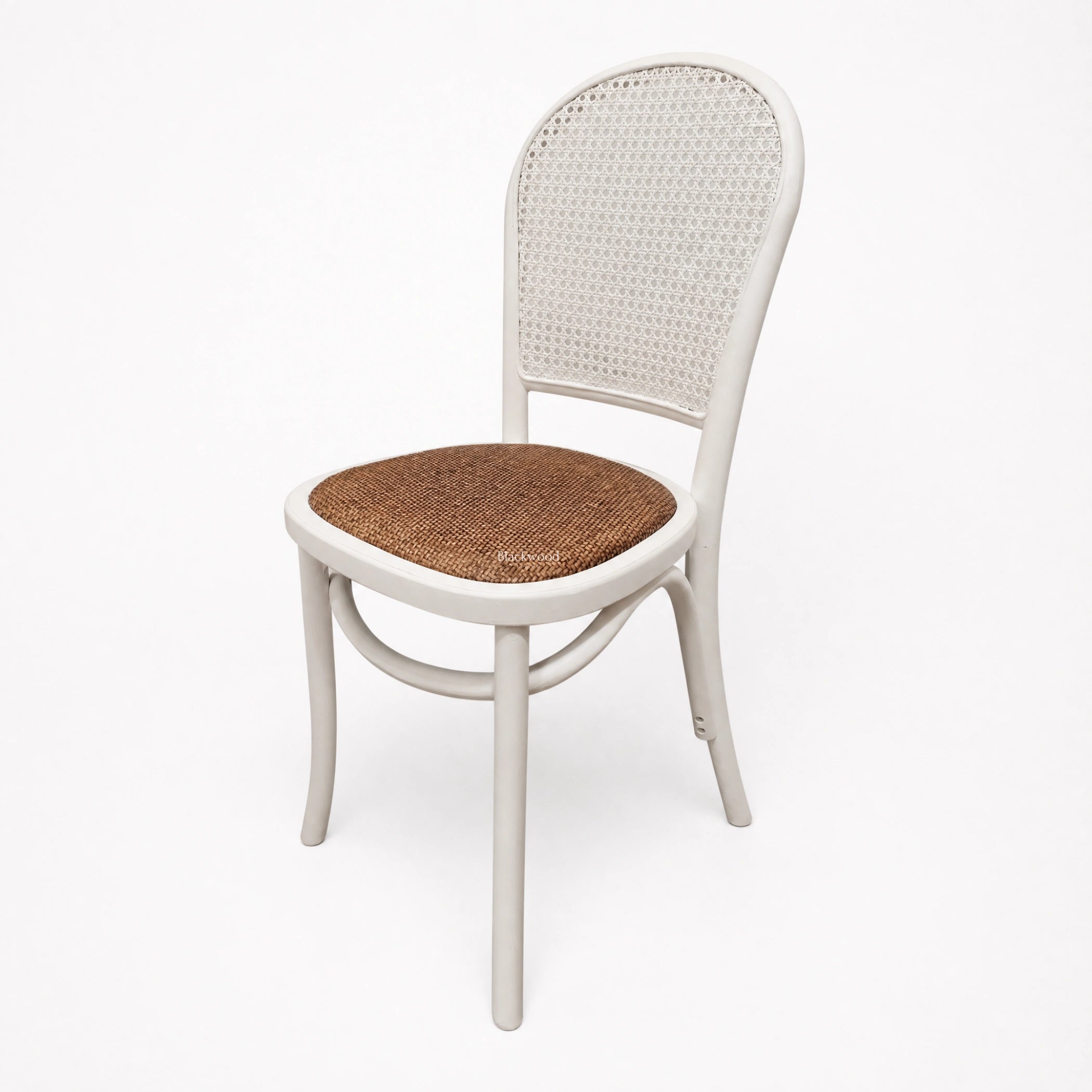 Whitehaven Dining Chair with white frame, caned back, and woven rattan seat.