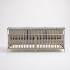 SIKA Exterior Caroline Sofa on a handwoven rattan frame with pale gray cushions.