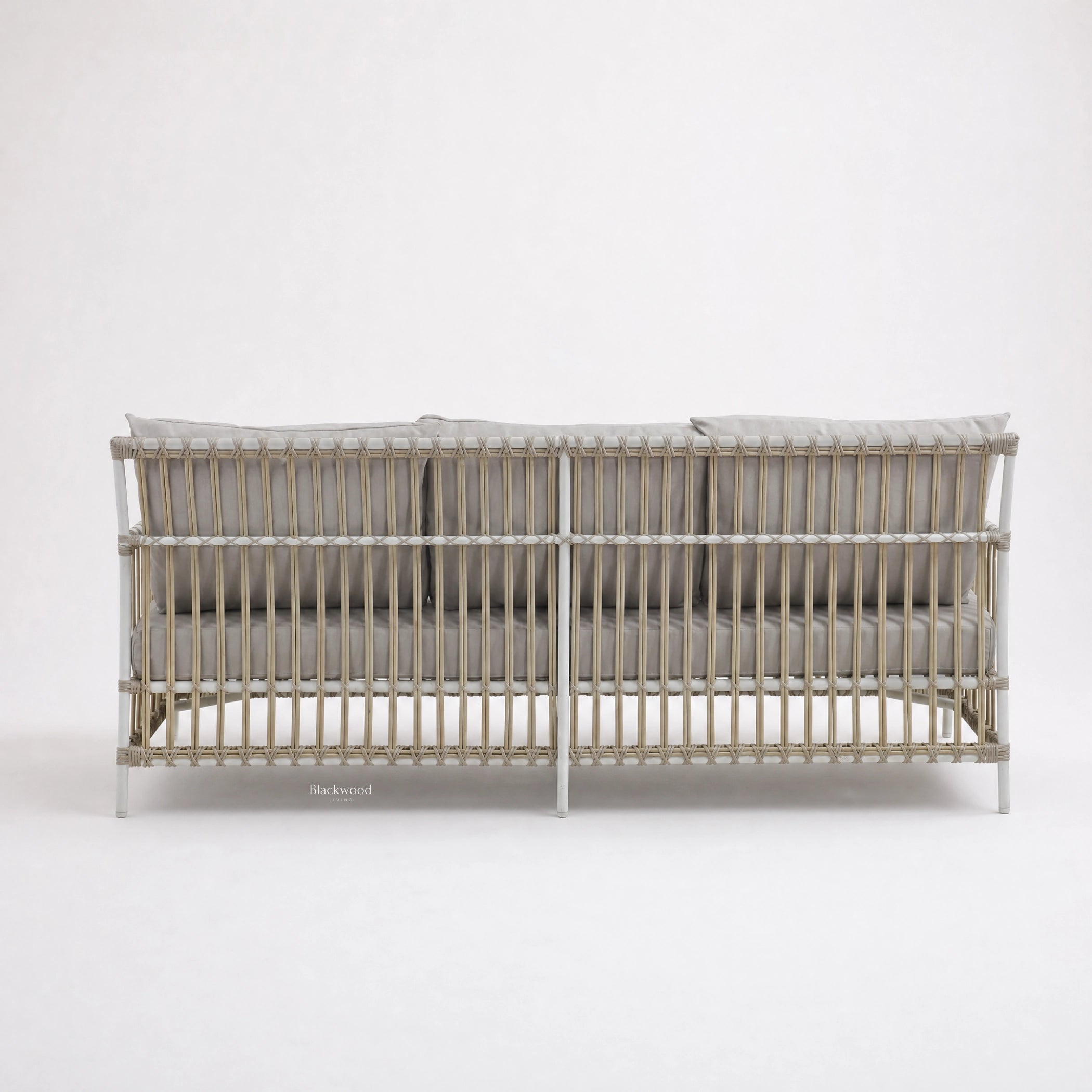 SIKA Exterior Caroline Sofa on a handwoven rattan frame with pale gray cushions.