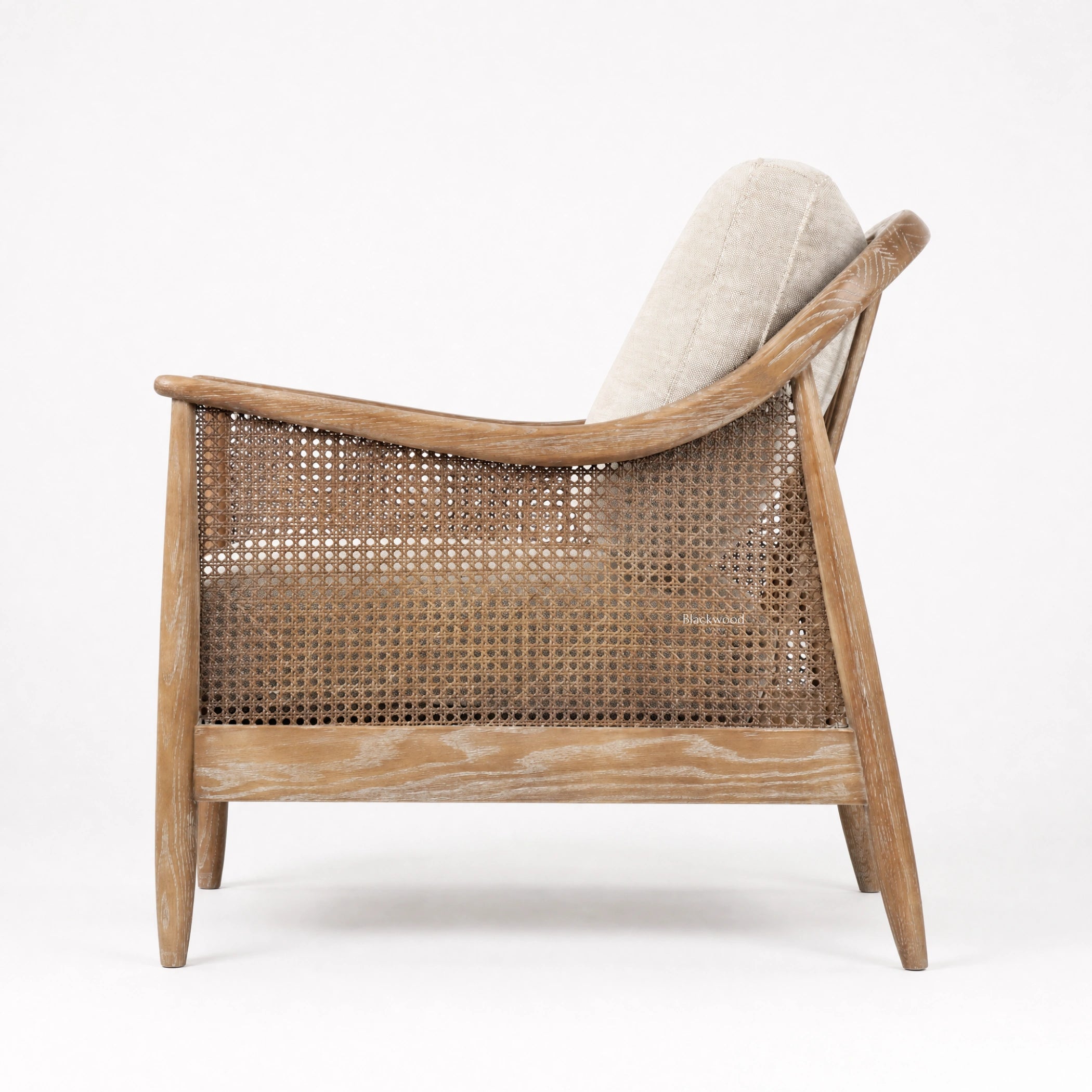 Devonport Chair with ash frame, whitewashed finish, natural rattan detailing, caned back, and upholstered cushions.