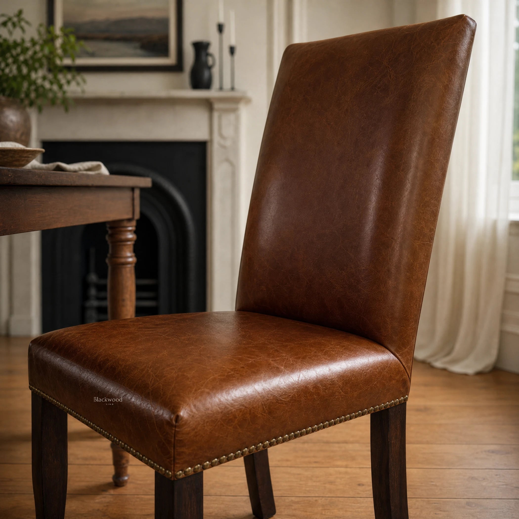 Manor Dining Chair in brown top-grain cowhide leather with brass nailhead trim and dark wood legs.