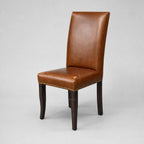 Manor Dining Chair in brown South American top-grain cow leather with hand-applied brass studs and dark wood legs.