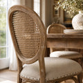 Camille Dining Chair with burnt oak, handwoven rattan back, and linen upholstered seat in French Provincial style.