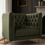 Wellington Club Chair - Green Velvet, with deep button tufting and gold legs, in luxe living room beside a fireplace.
