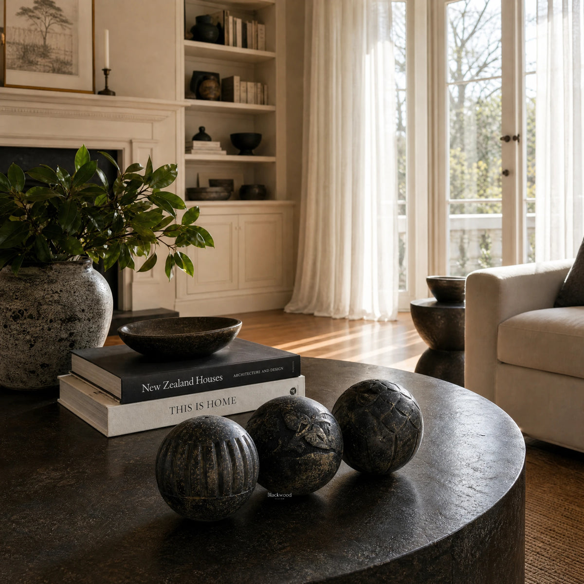 Vinewood Decorative Spheres Black, mango wood spheres with patterns and a textured finish on a dark coffee table.
