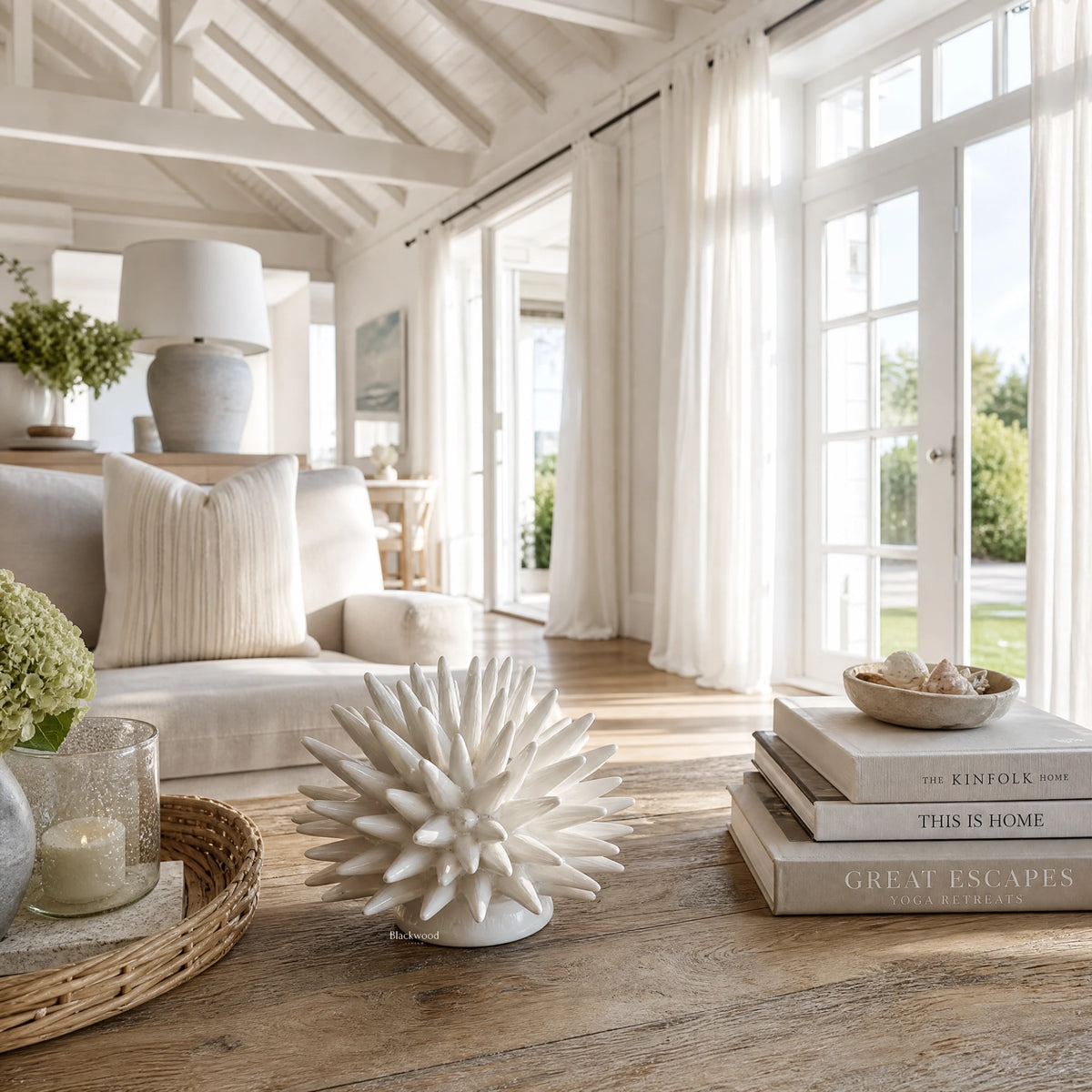 Ceramic Urchin sculpture on a wooden table in a sunlit, coastal-inspired living room.