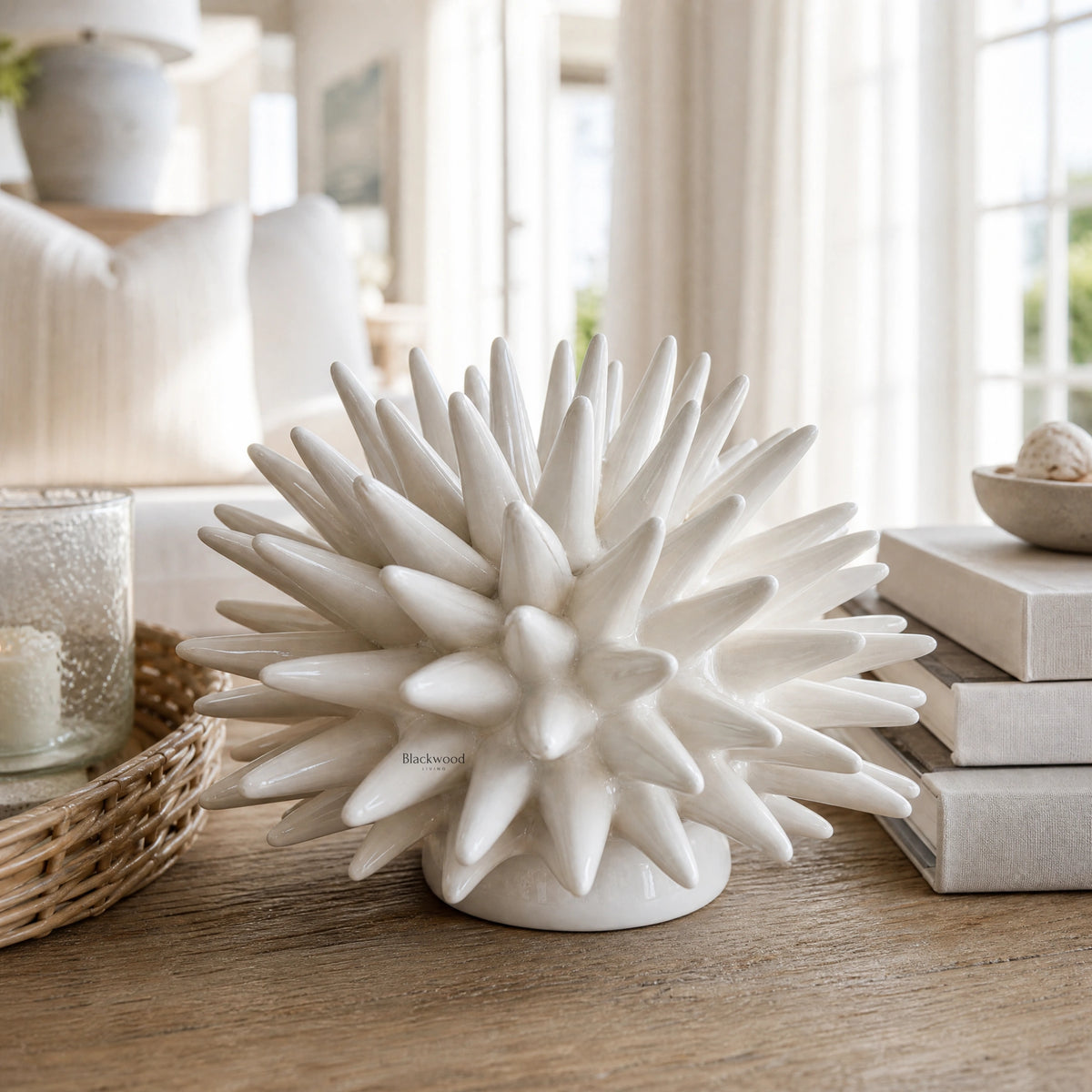 Ceramic Urchin sculpture with radiating spikes, white glaze, textured coastal-inspired decor.