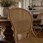 Sika® Rossini Rattan Side Chair, classic curved rattan weave and natural finish, in dining room setting.