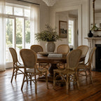 Sika Rossini Rattan Side Chairs around a round wooden dining table in a bright, classic room with woven cane seats.
